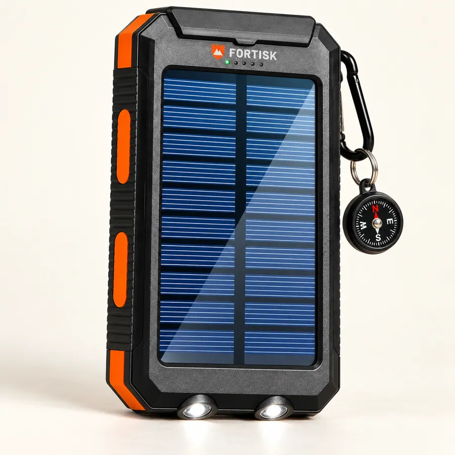 Fortisk solar power bank with a compass hanging from its carabiner and twin flashlight lenses on the bottom edge